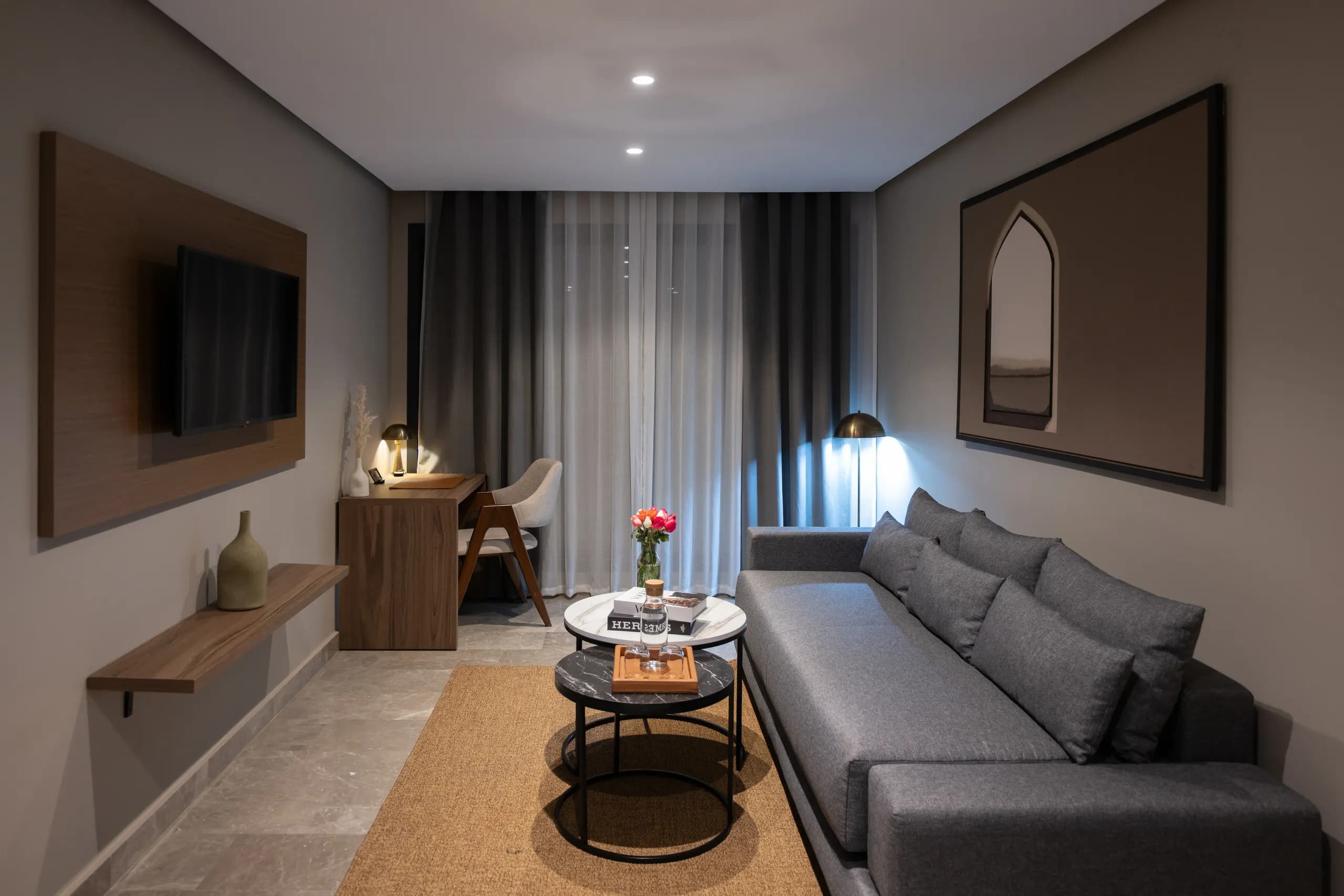 Salon d'une suite avec canapé et télévision murale